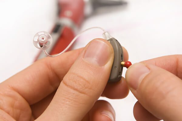 Audiological Services hearing aid repair technician repairing a hearing aid